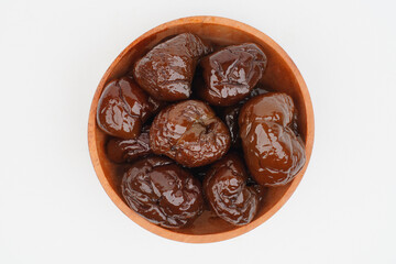 Dried plums in a wooden bowl Isolated Background