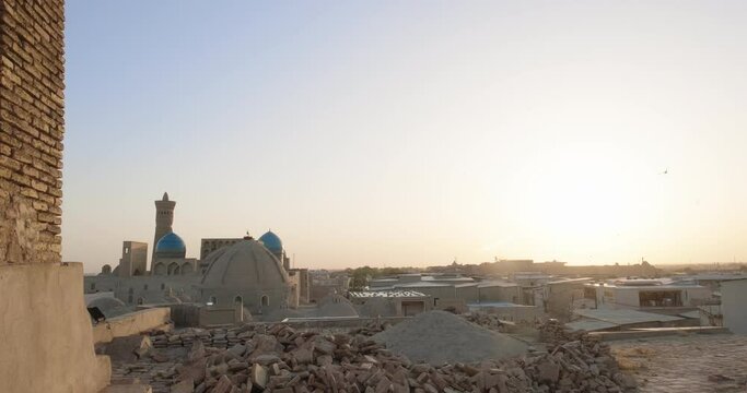 Old Bukhara from the roof at sunset. Birds flying over Po-i-Kalan or Poi Kalan complex at sunset. Handheld shoot