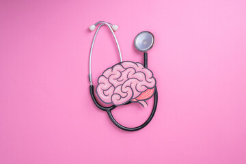 Stethoscope with human brain cutout paper. Health or pathological condition of human brain, diagnosing diseases of nervous system.