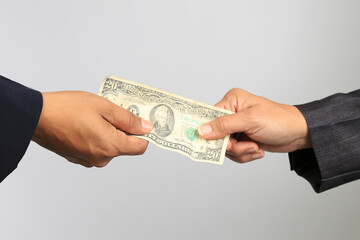 Close-up of two businesswomen's hands exchanging a twenty American balboas bill with white background.