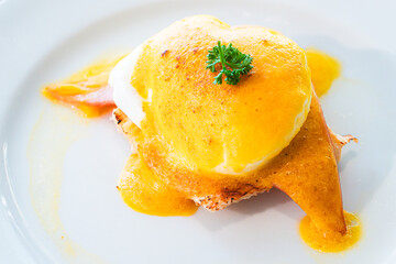 Eggs Benedict- toasted English muffins, ham, poached eggs, and delicious buttery hollandaise sauce : close up. - 766751910