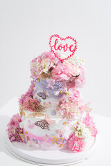 pink wedding cake with decoration with pink flower and cream on white,Food and flower wedding concept.