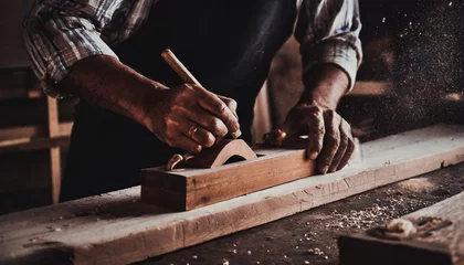 Cercles muraux Vielles portes Carpenter's hands planing a plank of wood with a hand plane, in factory, old, dark 