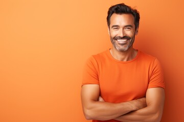 Portrait of handsome smiling man in orange t-shirt on orange background
