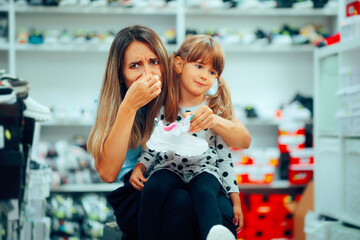 Mom Horrified by the Smell of Low-Quality New Shoes. Unhappy family trying to find properly made...