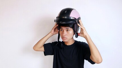 Young Asian man gesturing using a helmet