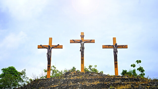 Three crosses of Jesus Christ on the hill on blue sky background. Easter - The passion of Jesus Christ. Good Friday. Holy week backgrounds.