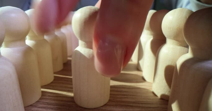 Woman puts white pawn in row covering red figure in crowd