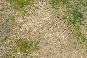 aerial top view of green grass background with tractor wheel tracks. drone photo. - 766765739
