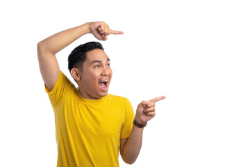 Shocked young Asian man pointing finger at empty copy space isolated on white background. Advertising and presentation concept