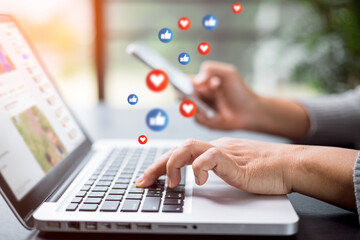 Social media concept. Young female using smart phone, Business woman working on laptop computer in...