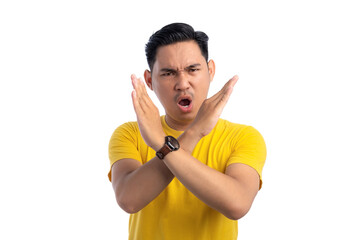 Angry young Asian man with crossed arms, showing stop or rejection gesture isolated on white...