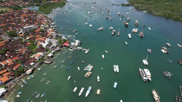 Panoramic aerial footage Serangan district and boats in Keramba Wayan Apel Strait on sunny day. Denpasar, Bali.