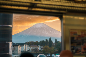 View of Mount Fuji at sunset through a train window. Mt. Fuji during transit at Kawaguchiko Station, Yamanashi, Japan. landmark for tourist attractions. Japan travel, destinations and vacations
