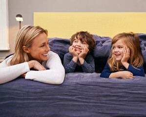 Home, mother and kids in bed with love, support and bonding together with a smile. Happy, family and children with mom in the morning in the bedroom relax with youth in a house with parenting