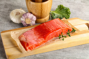 Raw salmon fillet over board
