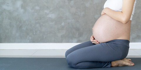Pregnant Woman Doing Yoga On Exercise Mat. meditating for near-term childbirth of meditating...