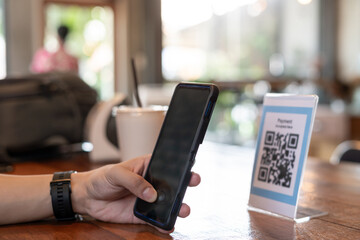 man use smartphone to scan QR code for order menu in cafe restaurant with a digital delivery....