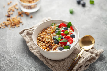 Homemade crispy granola, yogurt and berries in bowl on white background. Healthy breakfast