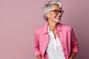 Portrait of a happy senior woman with eyeglasses over pink background