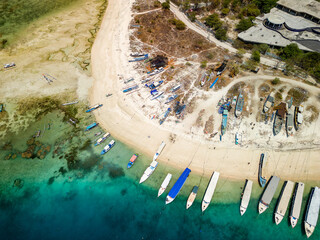 Birds eye view of wooden boats on the beach of a small tropical island