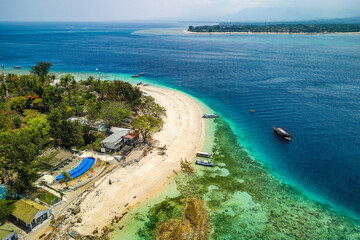 Aerial view of a reef table and coral reef off a tiny tropical island