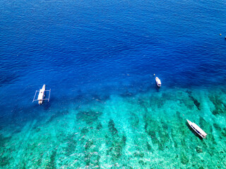 Swimmers and snorkellers from tour boats over a tropical coral reef in a clear, blue, warm ocean