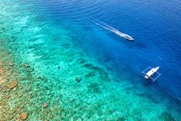 Swimmers and snorkellers from tour boats over a tropical coral reef in a clear, blue, warm ocean