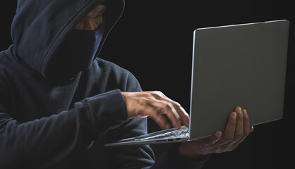 Hand hacker spy man one person in black hoodie sitting on table looking computer laptop used login...