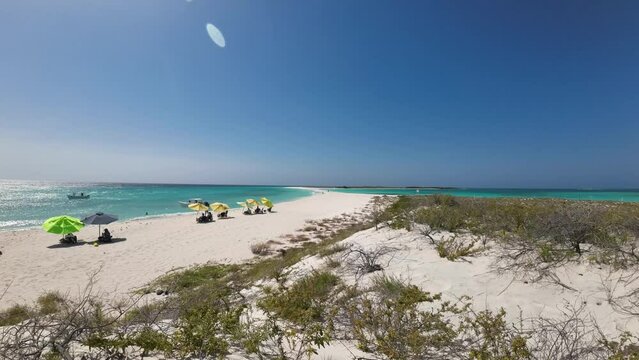 Secluded beach with people packing up camp on Cayo de Agua, clear skies, timelapse
