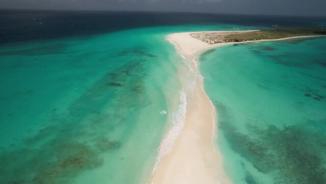 The sandy path at cayo de agua in los roques, venezuela, turquoise waters on both sides, aerial view