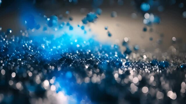 Blue glitter particles falling on black background in slow motion