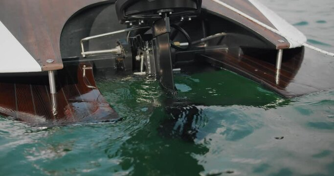 A shot of a powerful outboard engine starting, creating a splash of water.