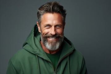 Portrait of a handsome mature man in a green hoodie. - obrazy, fototapety, plakaty