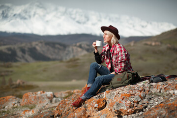 Portrait girl traveler with hat and mug on background of mountains - 766808162