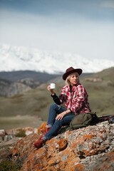 Portrait girl traveler with hat and mug on background of mountains - 766808177