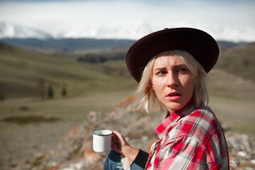 Portrait girl traveler with hat and mug on background of mountains - 766808358