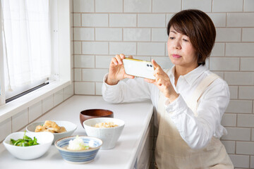 スマホで食事を記録する日本のミドル女性　栄養管理