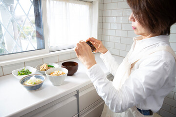 スマホで食事を記録する日本のミドル女性　栄養管理