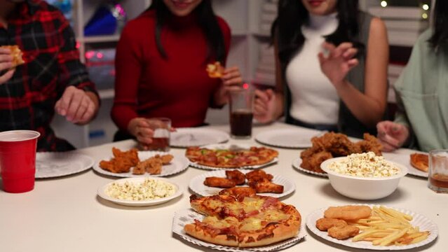 Group of happy Asian young people with friends celebrating during party, food, pizza, snacks with drinks and delicious food. Holiday concept, lifestyle.