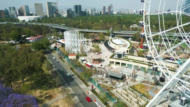Aerial view approaching the mechanical games and rollercoaster in Aztlán urban park Chapultepec, Mexico City.