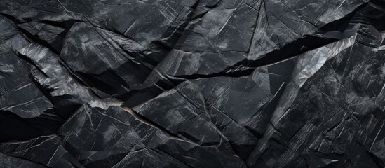 A person is seen walking on a detailed close-up of a dark black rock surface