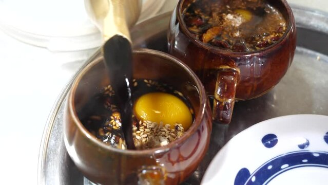 잣 호두 대추를 가득 넣은 뜨끈한 쌍화차에 달걀 노른자를 떨어트리는 모습