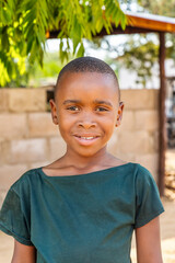 village life, african boy standing in front of the house