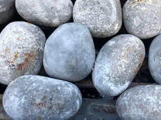 A collection of round gray stones. A group of gray cobblestones