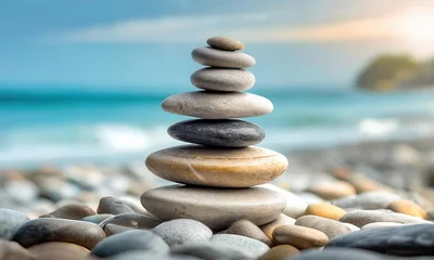 Gartenposter Pile of pebble zen stones stacked and balanced in harmony on the beach. Balance and stability concept. © Cagkan