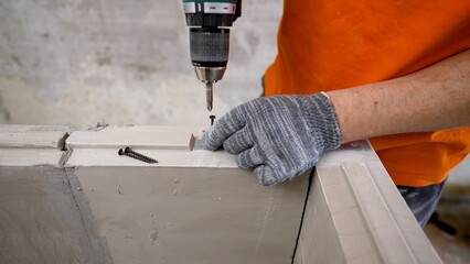 An electric drill is used to make a hole for attaching a steel rod to a reinforced concrete...