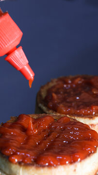 Flame-Kissed Flavor: Delve into the fiery allure of our custom hamburger bun as it receives a generous splash of our exclusive hot sauce, igniting a symphony of flavors, in this captivating stock phot