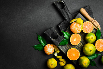Fresh ripe Tangerine orange. Top view, on a dark stone background. Autumn fruits. - obrazy, fototapety, plakaty