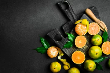 Foto op Plexiglas Fresh ripe Tangerine orange. Top view, on a dark stone background. Autumn fruits. © Yaruniv-Studio